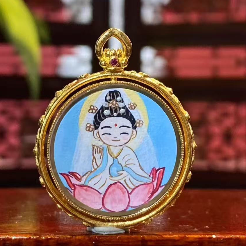 Front view of a Q-style Guanyin Thangka pendant, double-sided and hand-painted in 18K gold, crafted in the Rebgong art tradition and set in a Gau box