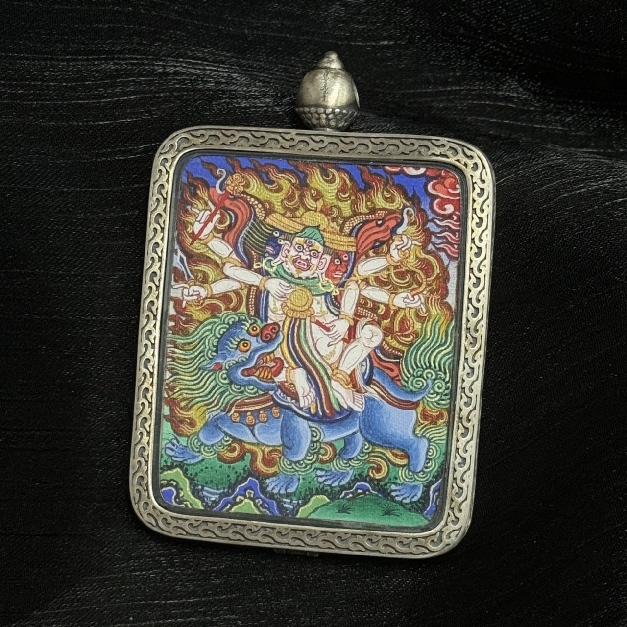 Detailed front view of Rebgong Baihar thangka pendant featuring precise iconography, mineral pigment colors, and engraved silver border