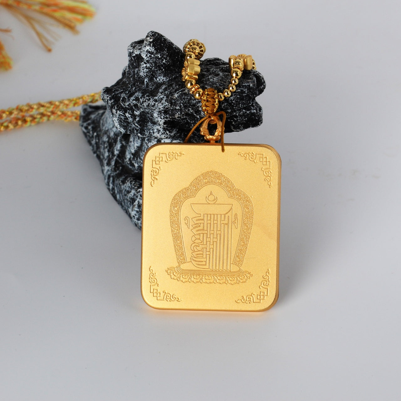 Back view of the Rebgong Gold Thangka pendant showing a matte gold-tone copper case with engraved Buddhist motifs and clean handcrafted finish.