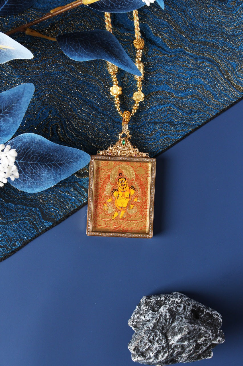 Front view of a Yellow Jambhala pendant featuring a fully hand-painted Rebgong gold thangka, set in a rectangular double-sided jewelry-grade titanium steel case with gemstone accents.