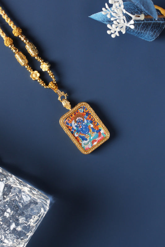 Close-up view of Six-Armed Mahakala mini thangka pendant, showing detailed mineral pigment painting, gold-tone frame, and pendant hanging structure