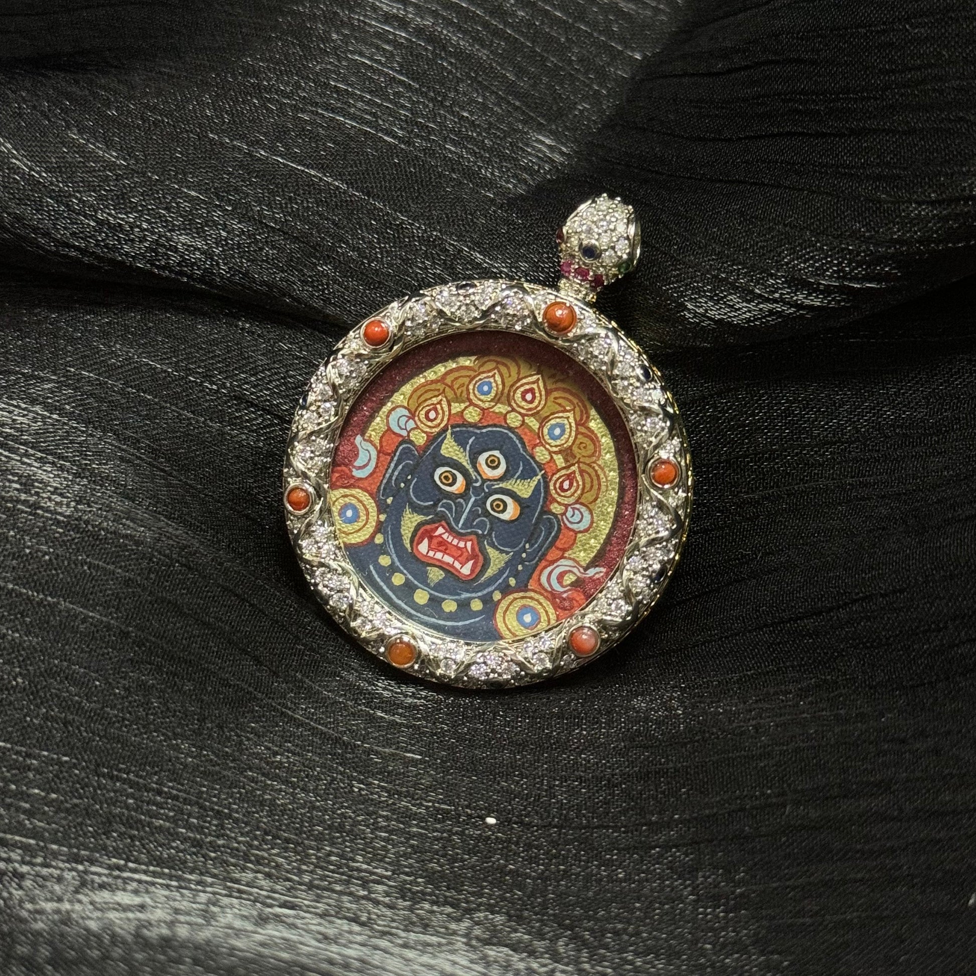 Close view of Acalanatha miniature thangka pendant framed in jeweled copper case, traditional Tibetan Buddhist devotional art