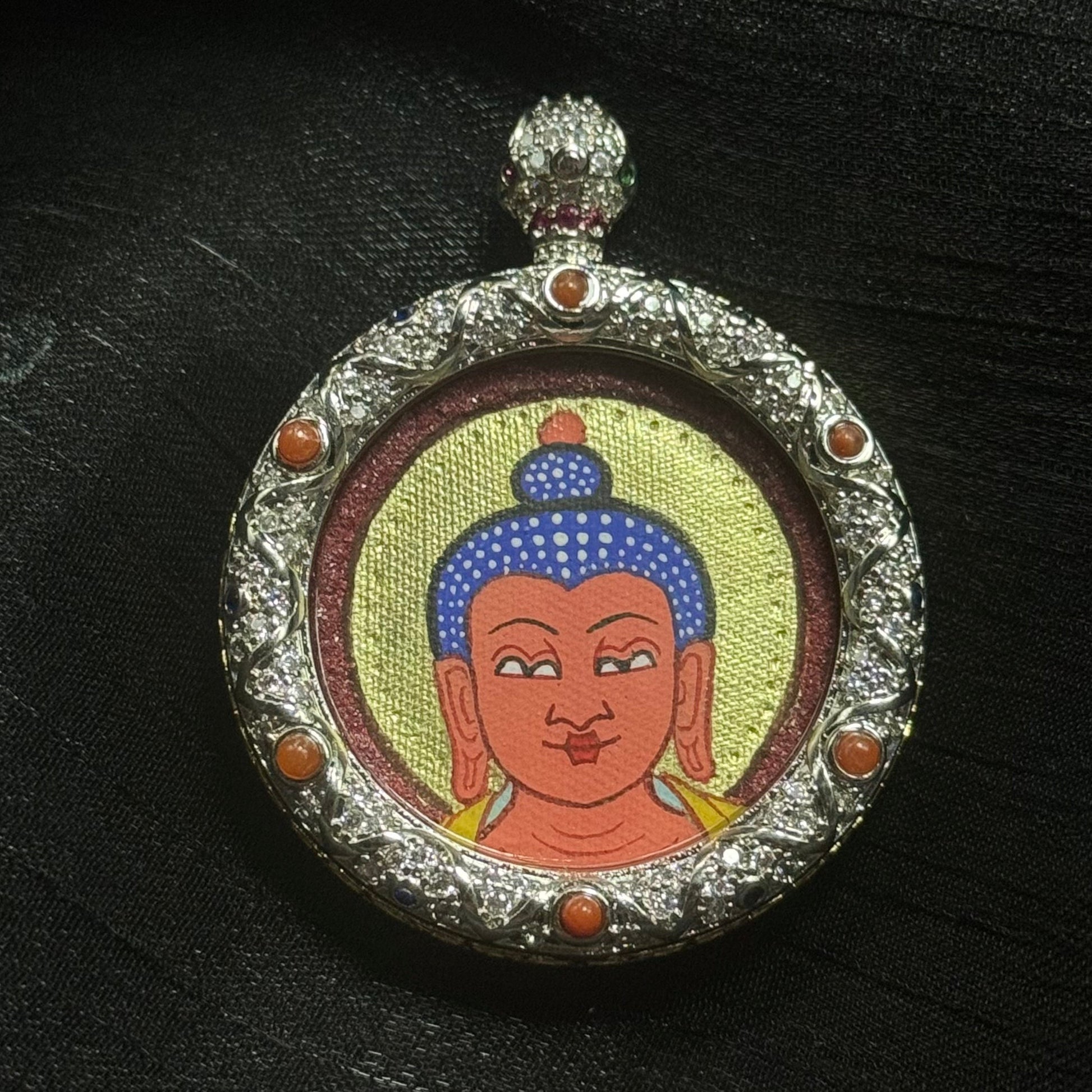 Close-up of Rebgong style red-gold Amitabha Buddha face mini Thangka, hand-painted with mineral pigments, coarse cinnabar red background and layered gold powder backlighting