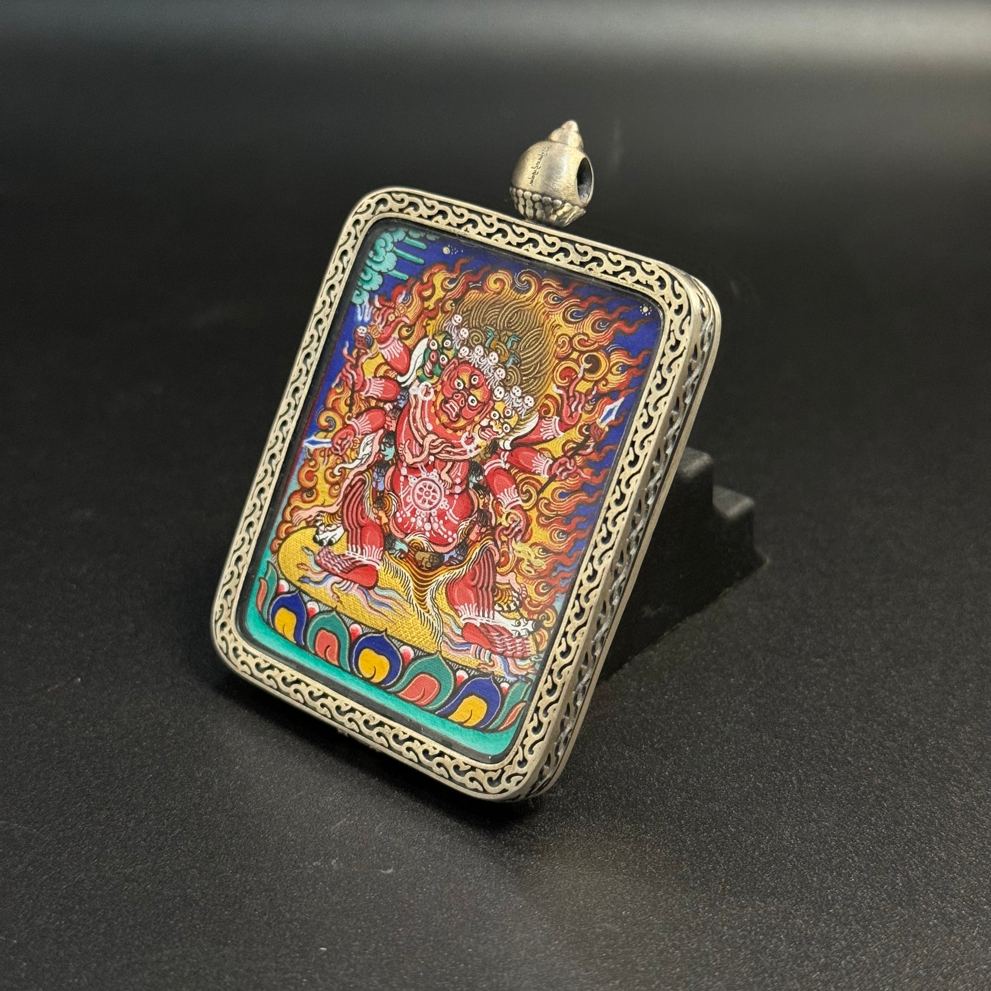 Close angled display of Hayagriva mini thangka pendant emphasizing detailed Rebgong hand-painted lines, dynamic flame patterns and layered mineral pigment colors.