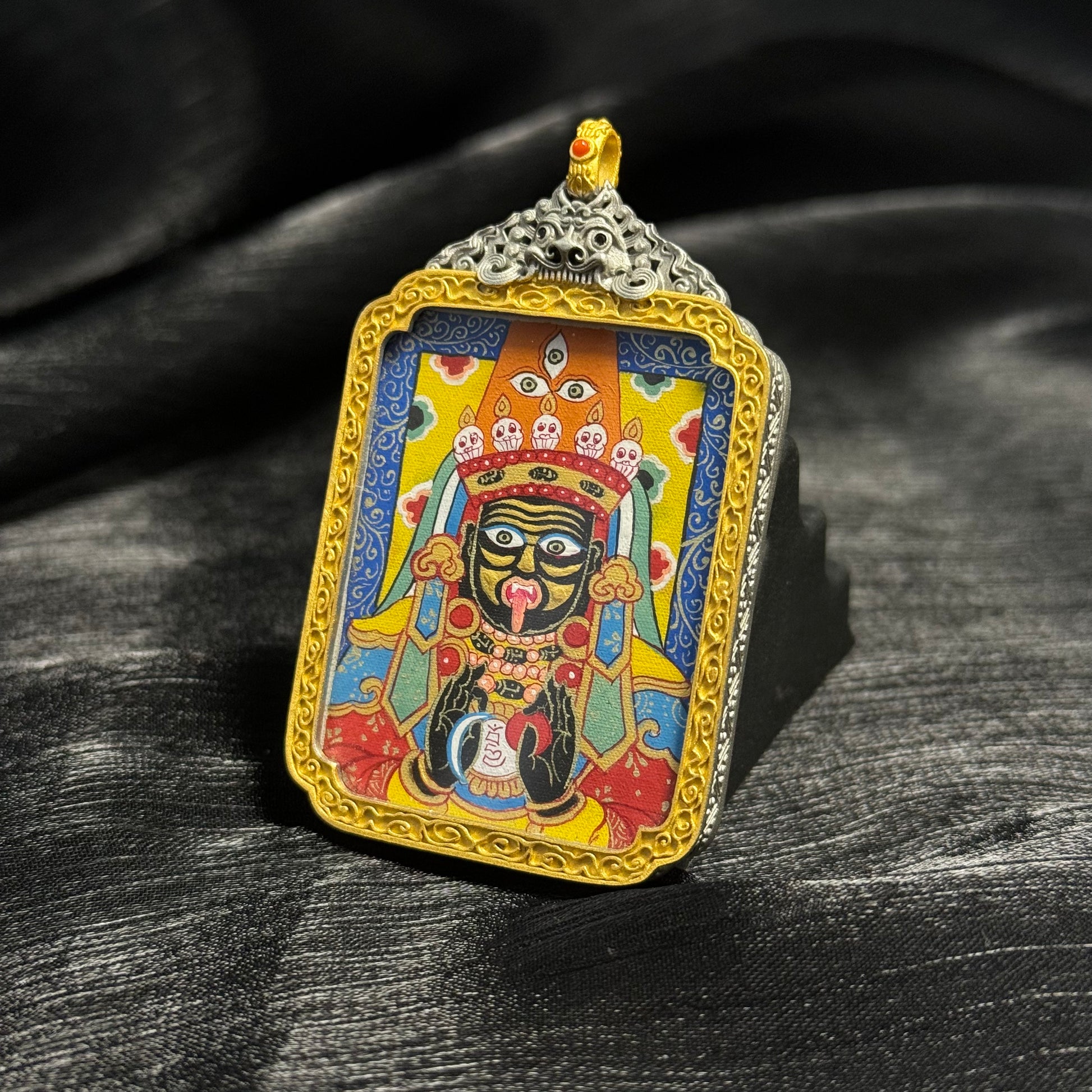 Detailed view of Zaki Lhamo Rebgong mini thangka pendant highlighting colorful mineral pigments, smooth linework, and traditional Tibetan thangka composition.