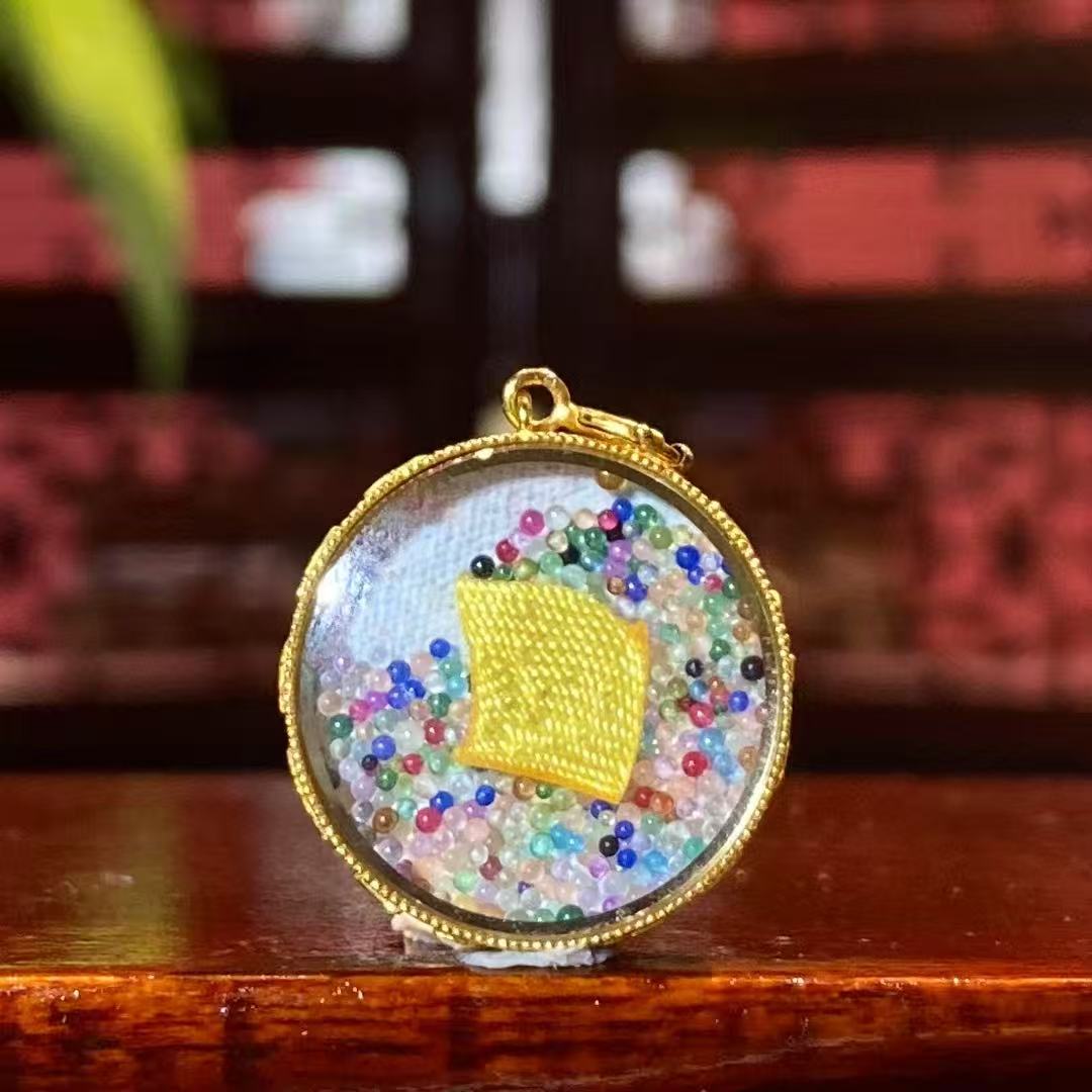 Back view of a round Tibetan Ghau Thangka pendant featuring seven-treasure glazed bead and khata symbolism