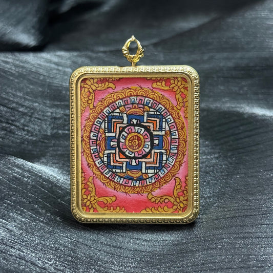 Hand-painted sacred mandala mini thangka pendant in a gold frame, featuring a traditional Buddhist mandala design with geometric patterns and symbolic cosmic structure.