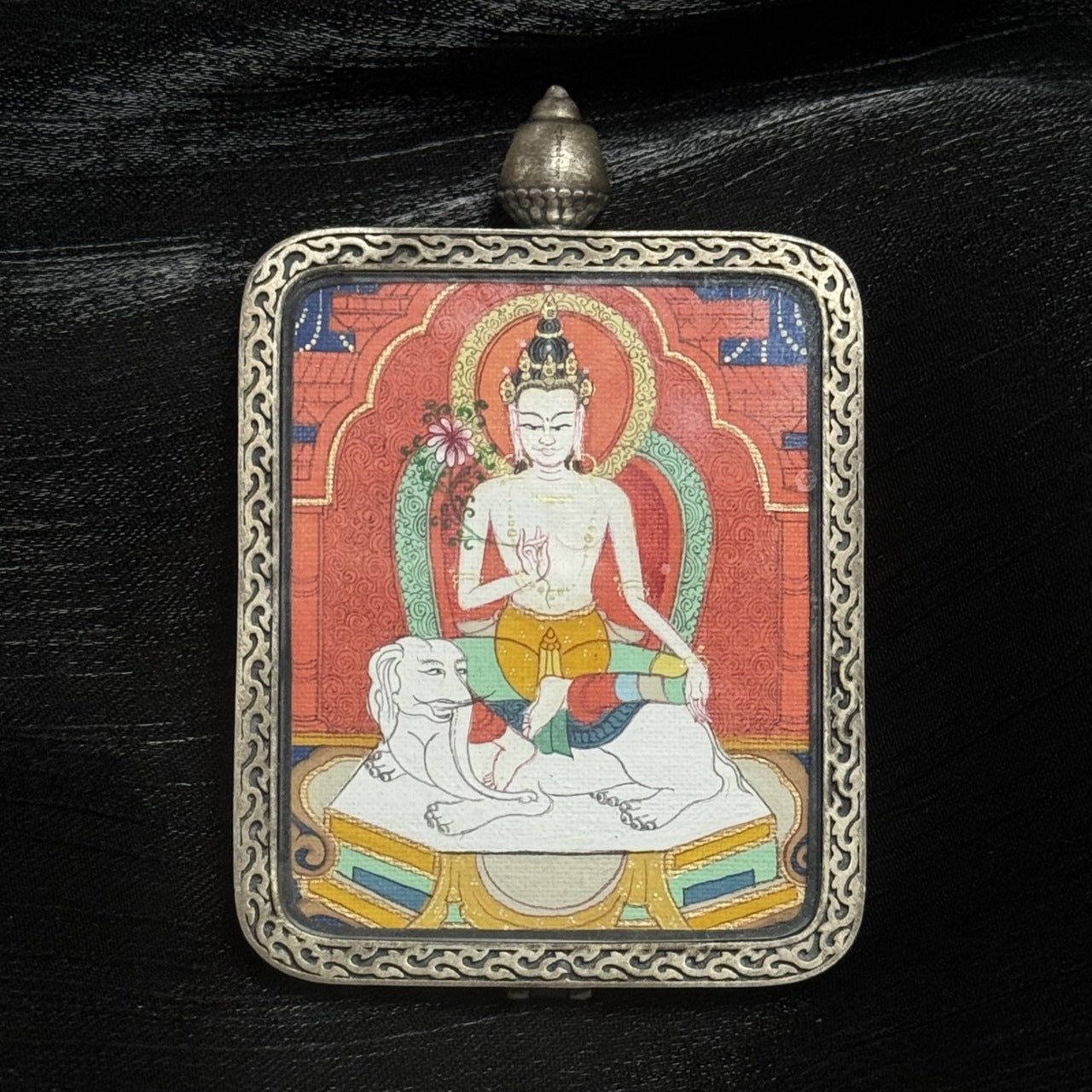 Close-up of Samantabhadra Bodhisattva miniature thangka pendant, traditional Tibetan Buddhist art in silver amulet case