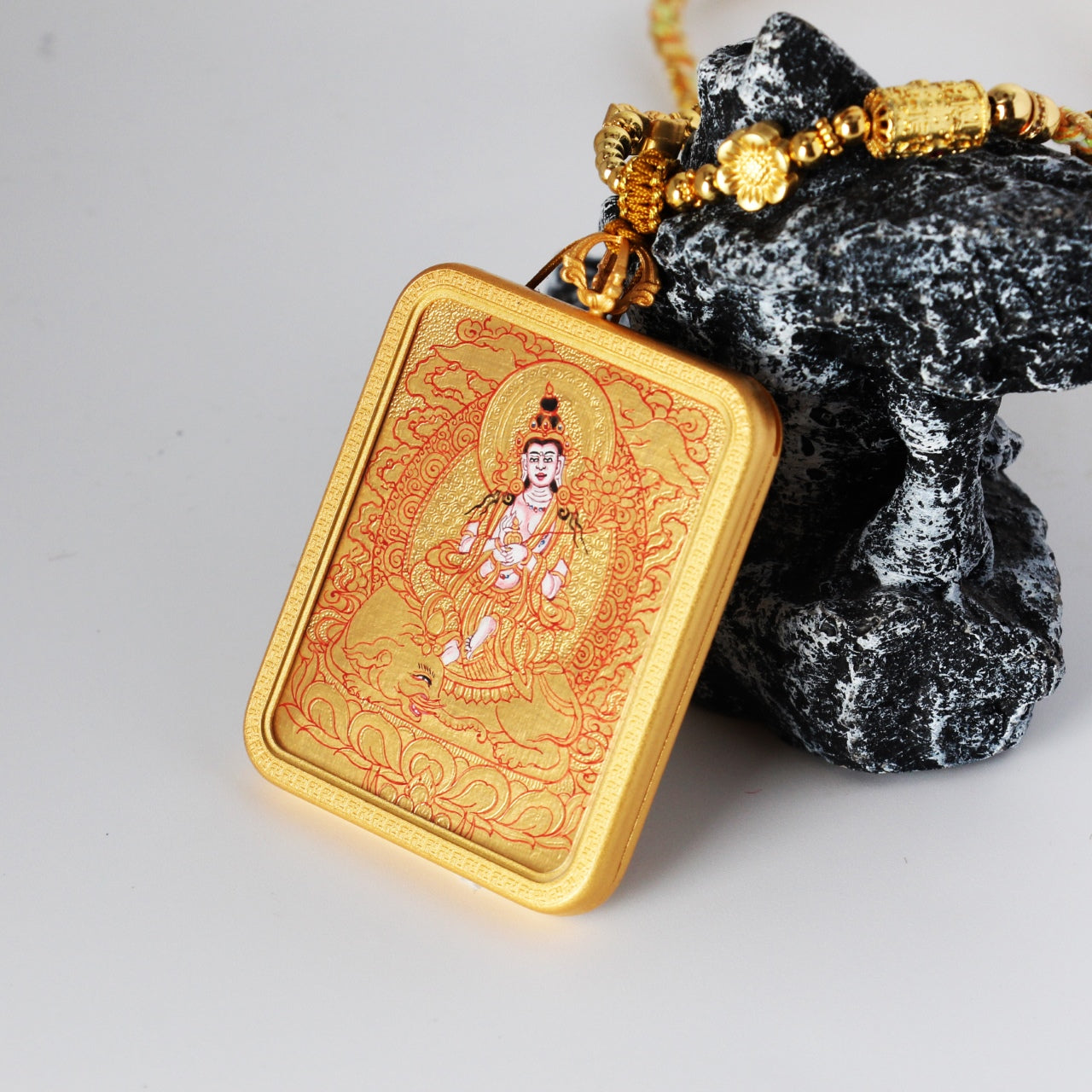 Angled view of the Samantabhadra Bodhisattva mini thangka pendant highlighting the thickness of the copper case, gold-ground painting surface, and layered mineral pigment texture.