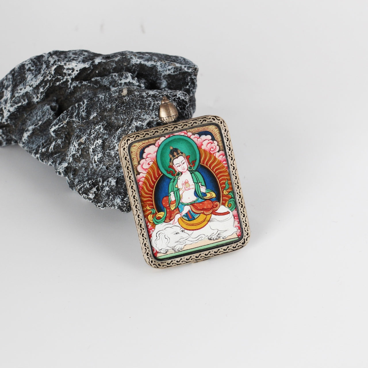 Angled view of a Samantabhadra Bodhisattva mini Thangka pendant, highlighting layered mineral pigment painting, refined line work, and the thickness of the silver gawu-style pendant frame.