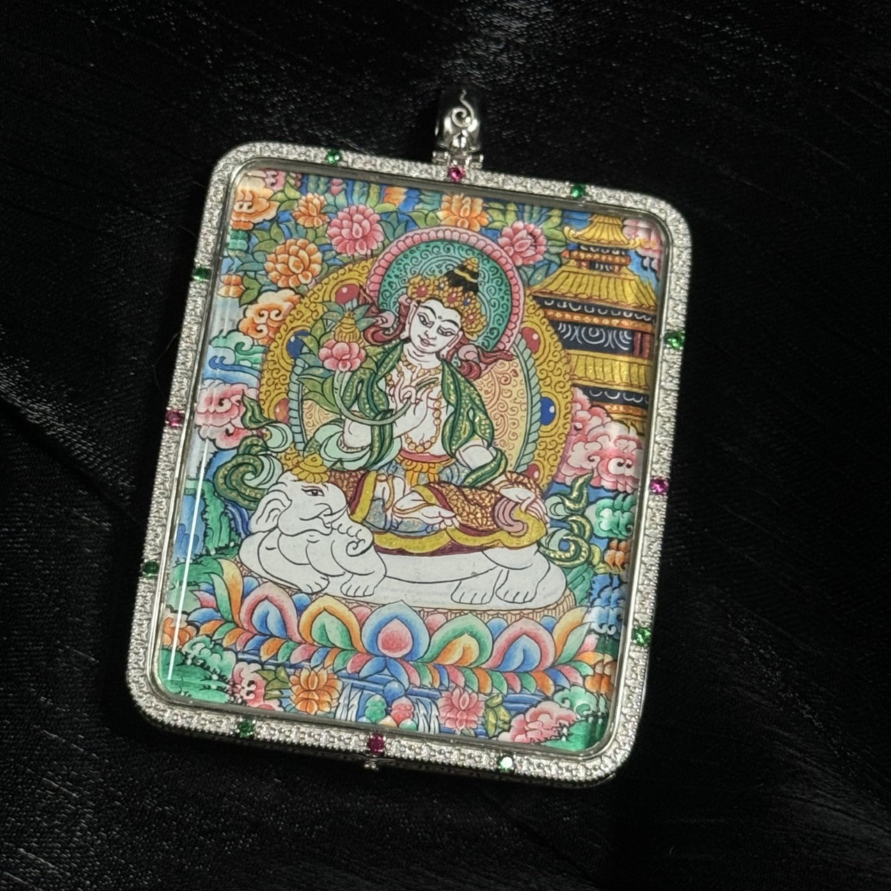 Close-up view of Samantabhadra Bodhisattva thangka pendant showing fine hand-painted details, floral background, lotus throne, and traditional Tibetan decorative elements.