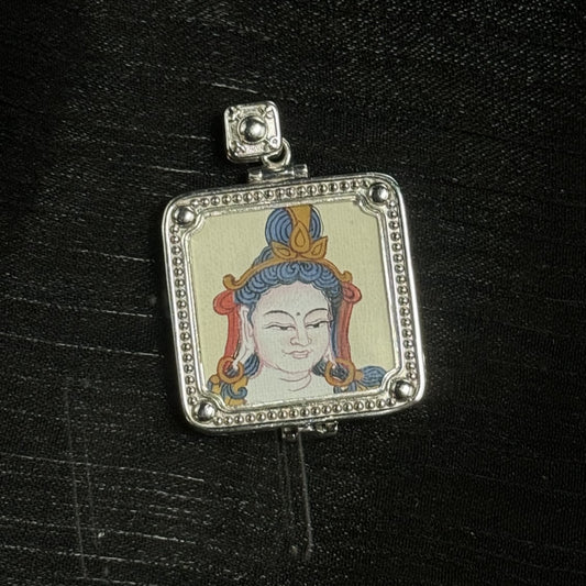 Close-up of Samantabhadra mini thangka pendant showing a single-sided hand-painted calm face with blue hair details and red ornaments, set in a square silver-tone frame with beaded border and raised round corner beads