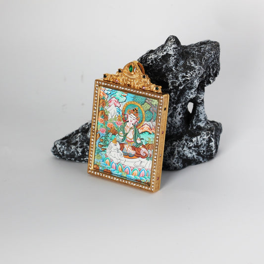 Angled view of the Samantabhadra Bodhisattva thangka pendant showing the jeweled border and gold-tone metal frame around the miniature painting.