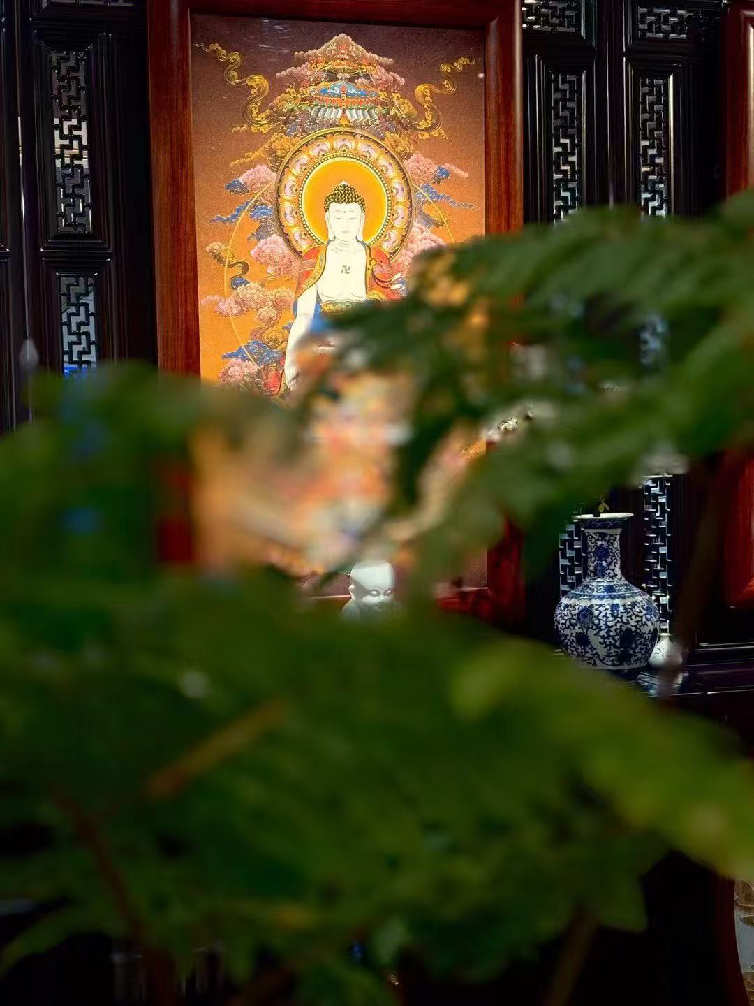 Close-up detail of Shakyamuni Buddha in a Rebgong gemstone thangka, highlighting fine line work and luminous colors created with natural mineral pigments.