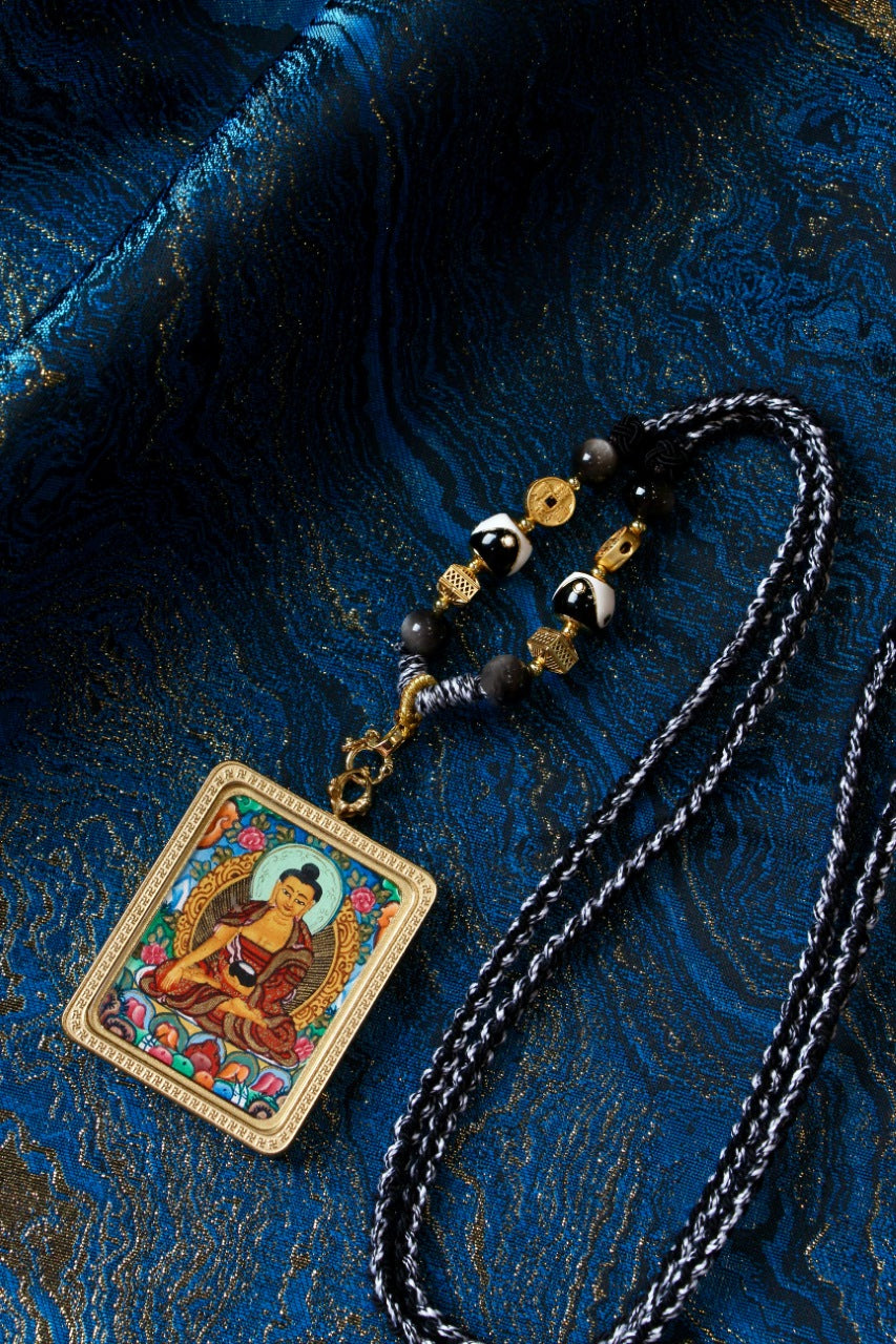 Shakyamuni Buddha mini thangka pendant worn with handcrafted necklace, Nepalese Color Thangka style with vivid colors and detailed line work
