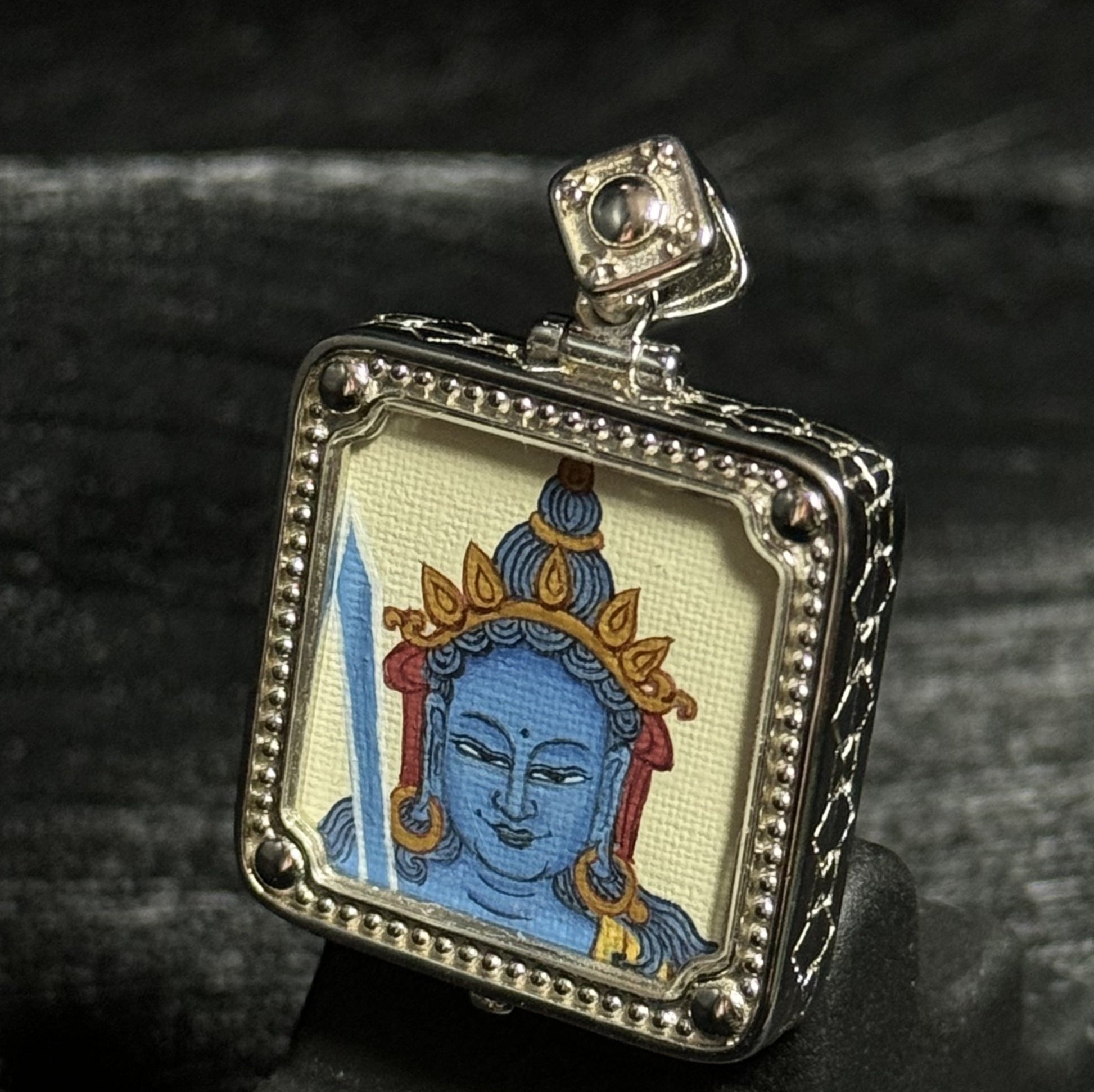 Side view of a miniature Akashagarbha Bodhisattva thangka pendant showing the hand-painted artwork and detailed silver pendant structure.