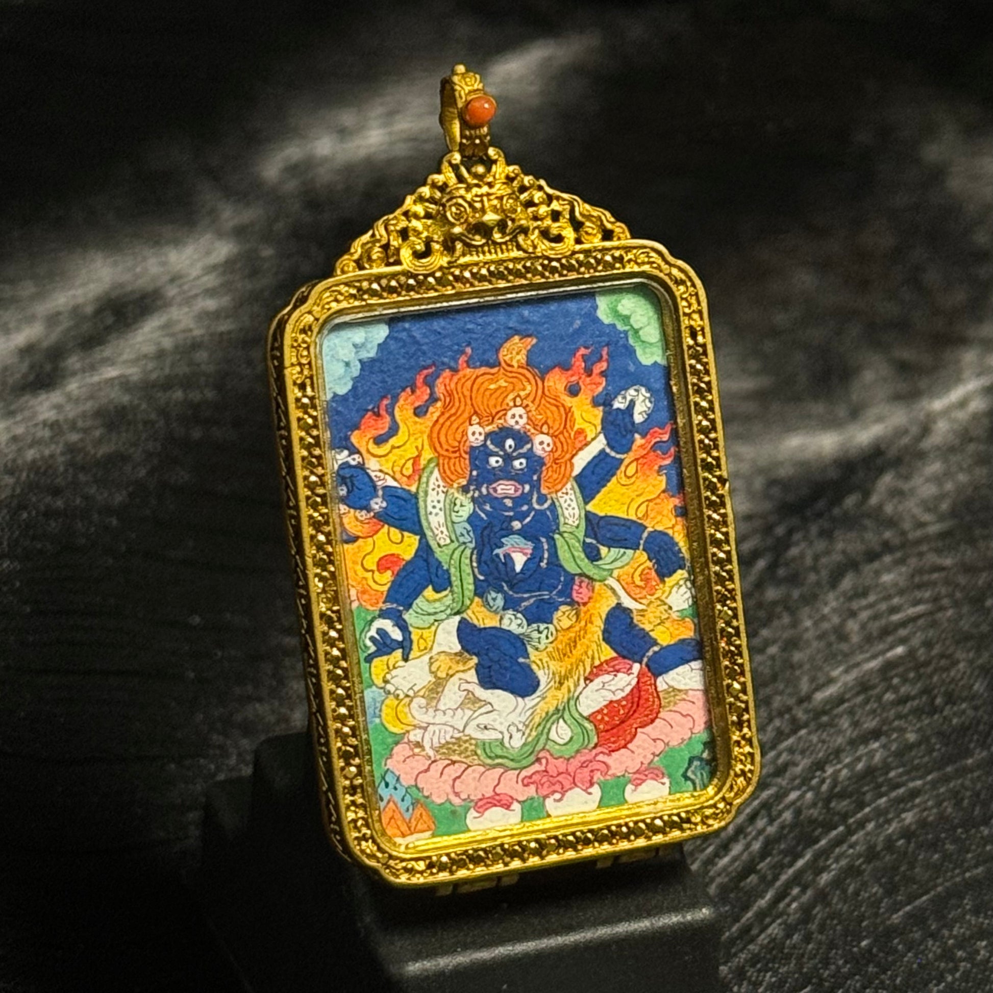 Angled view of Six-Armed Mahakala mini thangka pendant showing detailed hand-painted deity image and ornate Tibetan copper frame