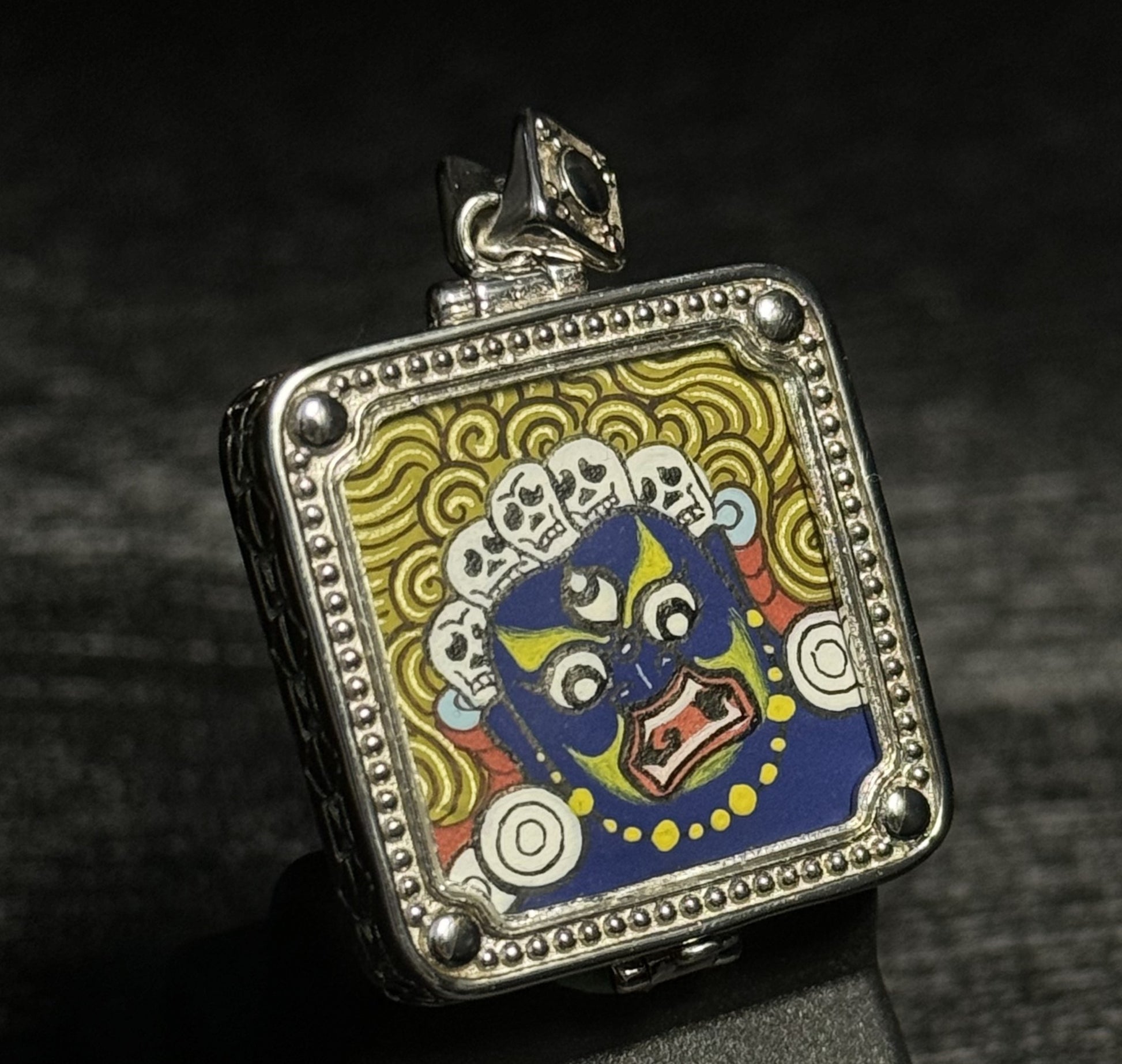 Top angled view of Six-Armed Mahakala miniature thangka pendant showing Tibetan gawu style pendant case and sacred protector deity painting