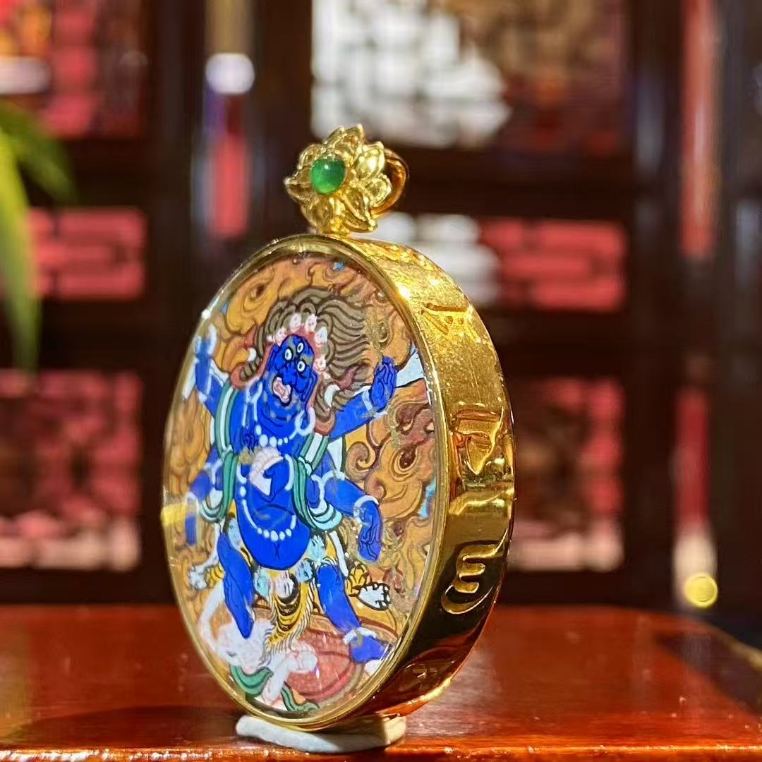 Side view of Tibetan Gau pendant featuring Six-Armed Mahakala, showing metal casing and sapphire crystal protective cover
