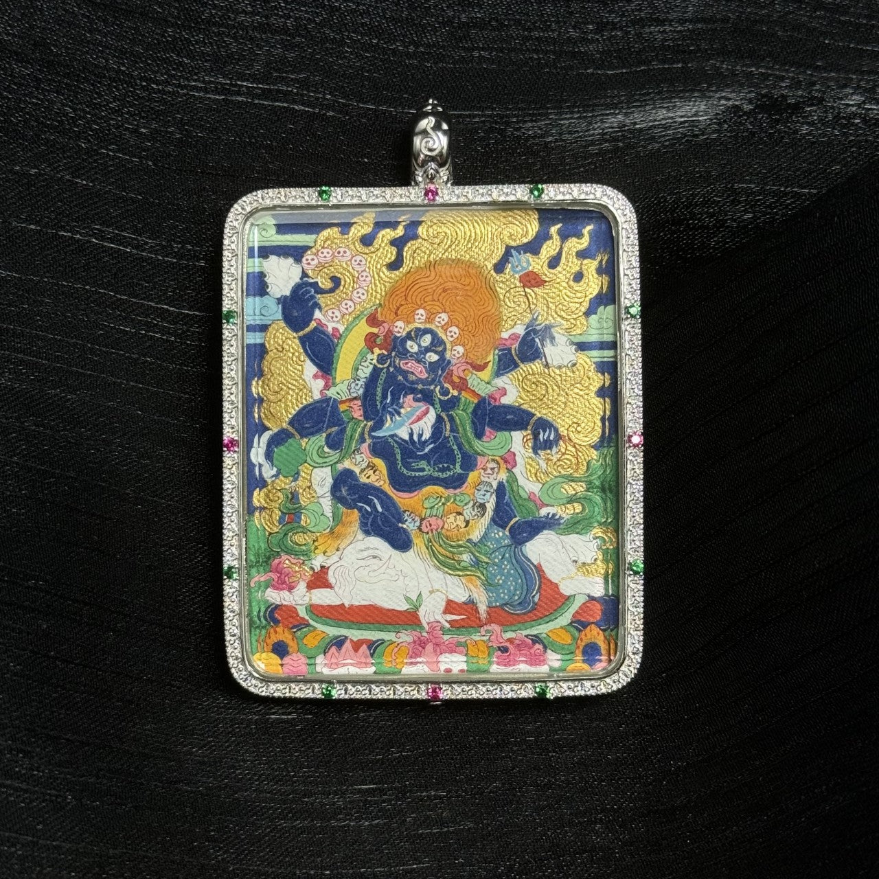 Front view of Six-Armed Mahakala thangka pendant featuring wrathful protector deity painted with mineral pigments inside ornate silver pendant frame