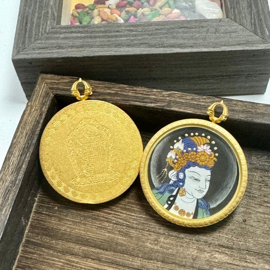 Front-and-back display of a Sudhana Avalokiteshvara mini thangka pendant, showing the hand-painted portrait on the front and the solid matte copper back with engraved pattern.
