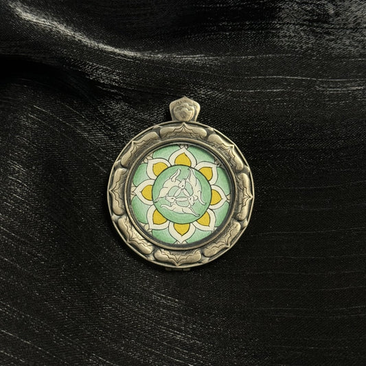 Detail view of pendant bail and 925 silver frame, oxidized silver texture, raised sculpted border surrounding the hand-painted three hares design