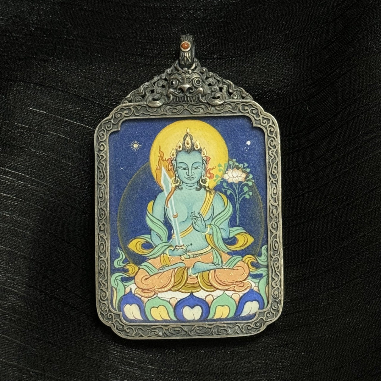 Full composition of Akasagarbha Bodhisattva mini thangka pendant featuring deep blue background, circular aureole, detailed silver border, and Tibetan iconographic proportions.