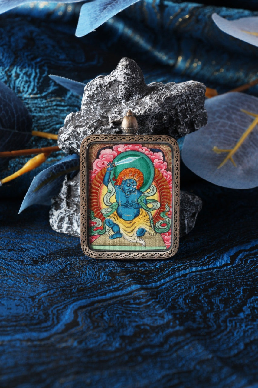 Acalanatha (Fudo Myo-o) mini thangka pendant displayed in a Tibetan-inspired setting, hand-painted using traditional mineral pigments
