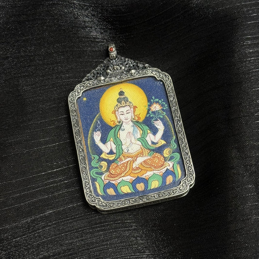 Front view of Four-Armed Avalokiteshvara mini thangka pendant showing golden halo, four-arm iconography, lotus seat, and layered mineral pigment background.