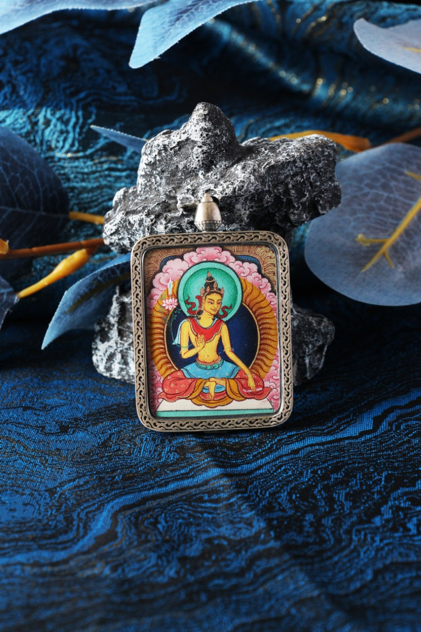 Manjushri Bodhisattva mini thangka pendant displayed in a Tibetan-inspired setting, hand-painted using traditional mineral pigments