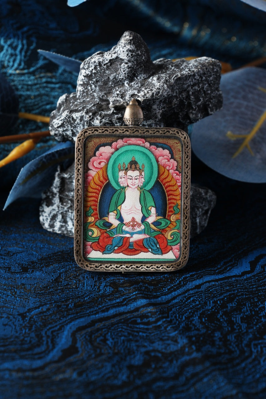 Vairocana Buddha mini thangka pendant displayed in a Tibetan-inspired setting, hand-painted using traditional mineral pigments