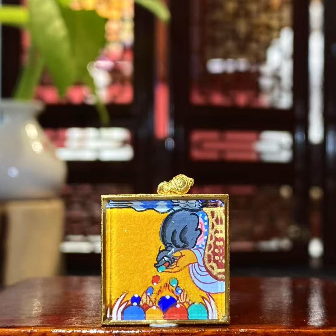 Back view of hand-painted treasure-spitting mongoose mini Thangka with flowing jewels, in an 18K gold Gau box with sapphire crystal