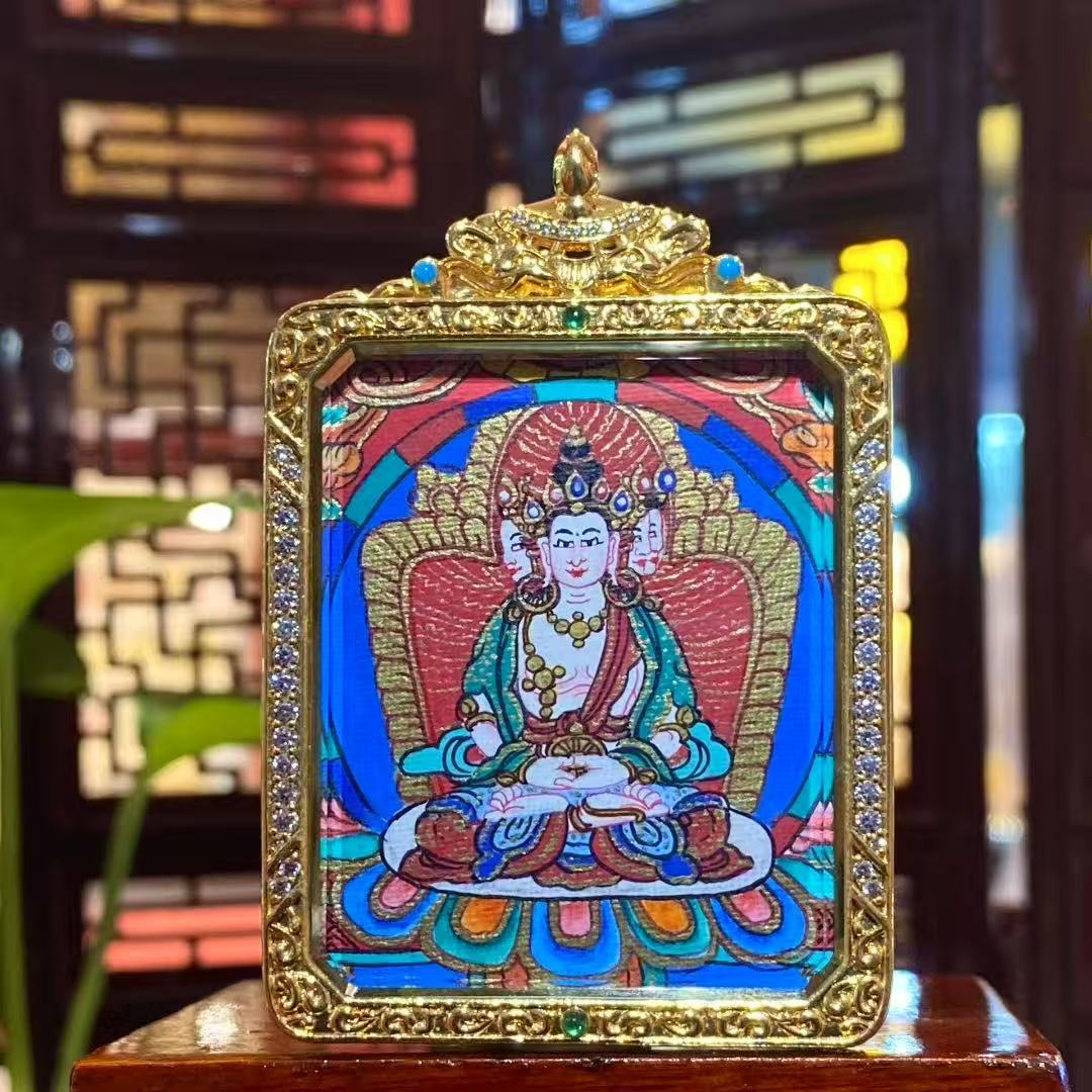 Front view of a double-sided hand-painted Vairocana Buddha mini thangka pendant set in a gold-plated copper Gawu box, 55×45mm