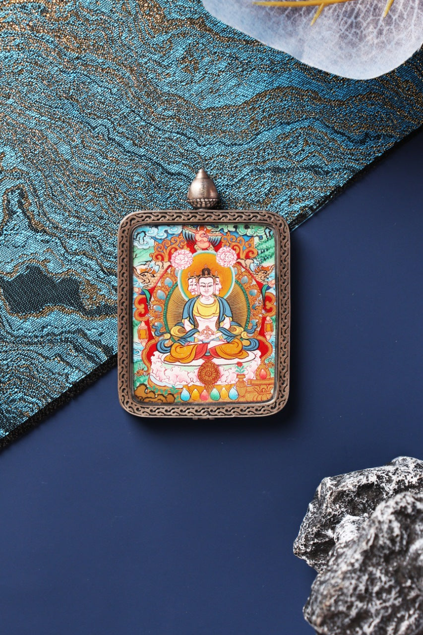 Centered product photo of a Vairocana Buddha Menri-style mini thangka card set in a silver gawu pendant case with ornate border.