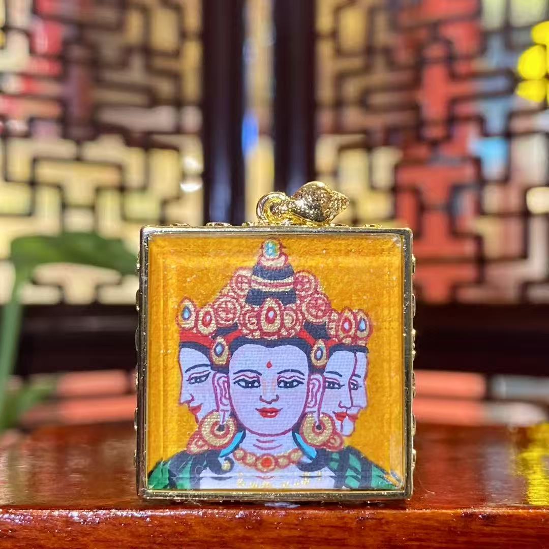Hand-painted Vairocana Buddha mini thangka pendant in a gold-plated copper Gawu box, front view showing the Great Sun Buddha