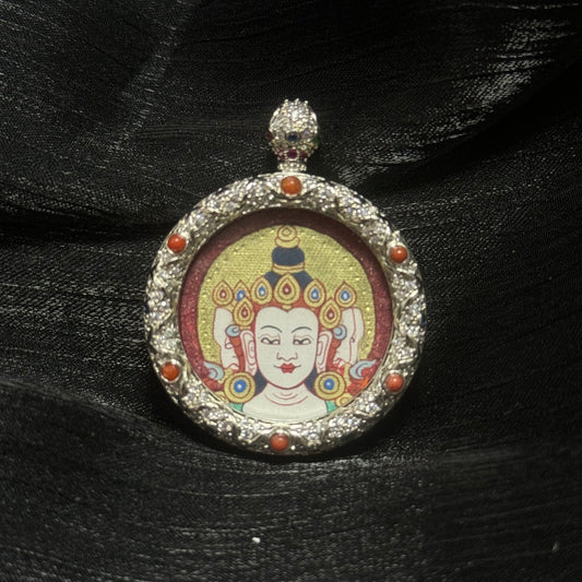 Close-up of Vairocana Buddha miniature thangka pendant showing hand-painted red gold Buddha head with cinnabar mineral pigment background and ornate jeweled copper pendant frame