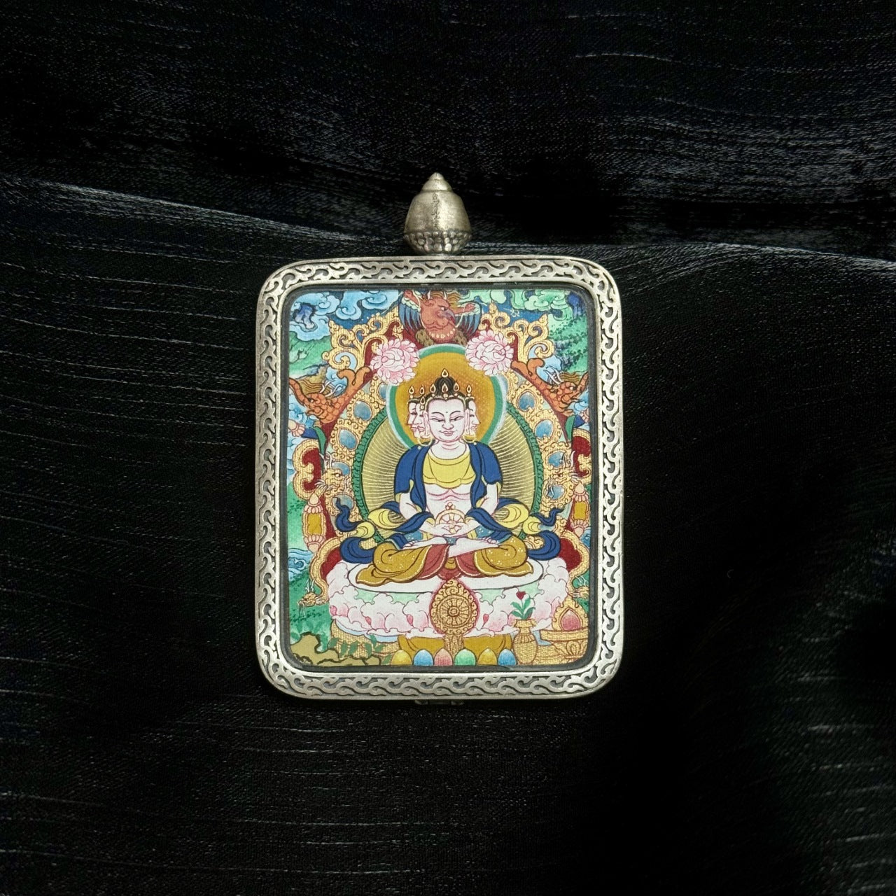 Front view of Vairocana Buddha mini thangka pendant, hand-painted with natural mineral pigments, set in Dunhuang Nine-Color Deer silver gawu case, 4x5cm Tibetan artwork.