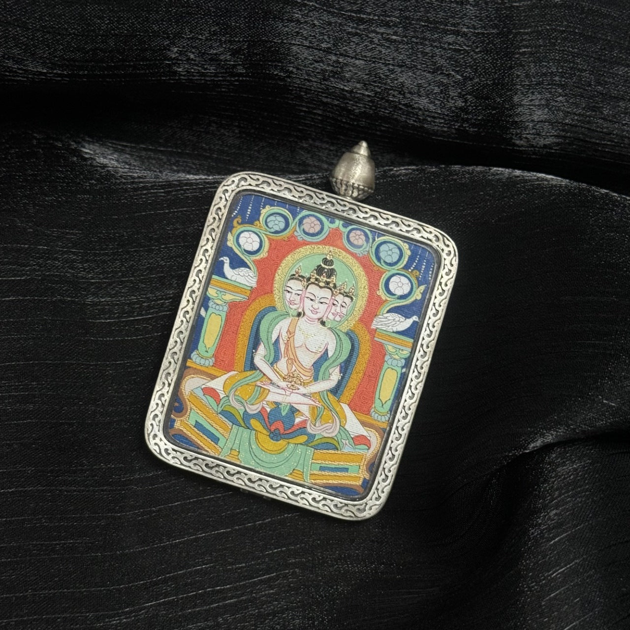 Front view of Vairocana Buddha mini Thangka pendant, hand-painted with mineral pigments and set in Dunhuang Nine-Color Deer silver case