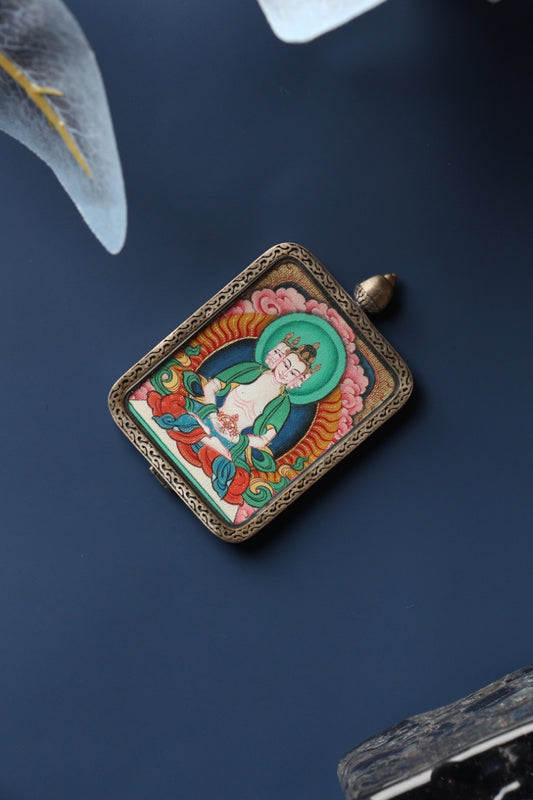 Front view of Vairocana Buddha mini thangka pendant, hand-painted with natural mineral pigments and set in a Tibetan silver gawu-style case