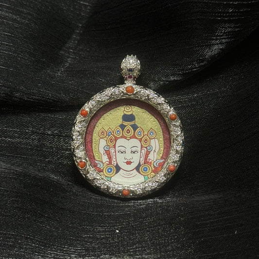 Angled view of Vairocana Buddha miniature thangka pendant highlighting layered gold halo painting, cinnabar mineral background texture, and decorative gemstone copper frame