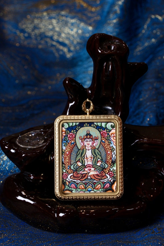 Hand-painted Vairocana Buddha thangka pendant from Nepal, featuring mineral pigments and traditional Buddhist iconography in a gold-tone pendant frame