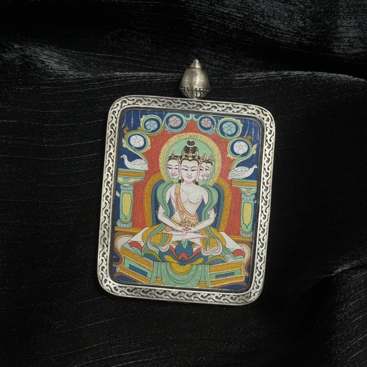 Close-up detail of hand-painted Vairocana Buddha Thangka pendant showing mineral pigment layering and traditional Tibetan iconography