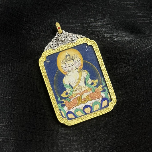 Angled view of a Tibetan Vairocana Buddha mini thangka pendant, hand-painted with mineral pigments and set in an ornate electroplated silver case.