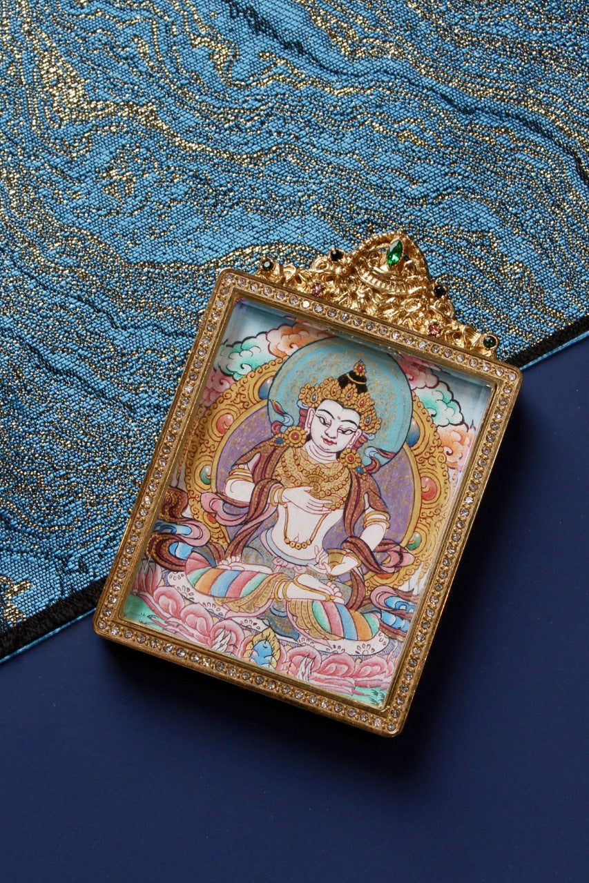 Close-up detail of Vajrasattva mini thangka pendant showing fine hand-painted lines and mineral pigment colors inside a jeweled double-sided titanium steel case