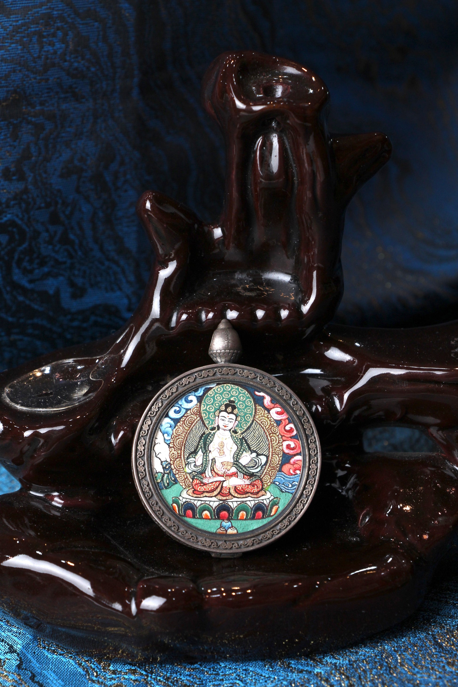 Vajrasattva mini thangka pendant displayed on traditional textile, fully hand-painted Rebgong style cloud background with 925 silver pendant frame