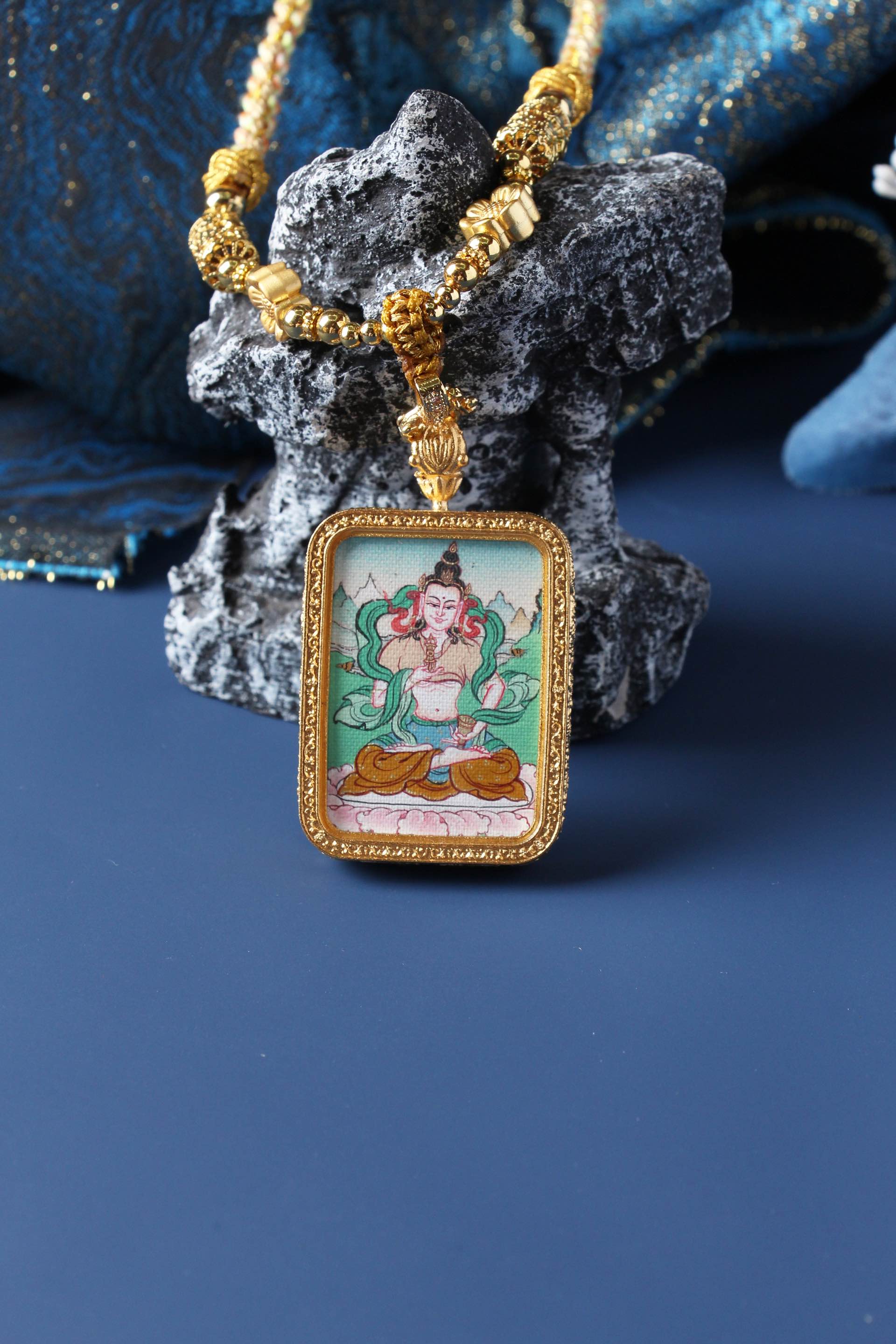 Vajrasattva mini thangka pendant photographed upright, highlighting rectangular gold-tone double-sided titanium steel case and balanced composition
