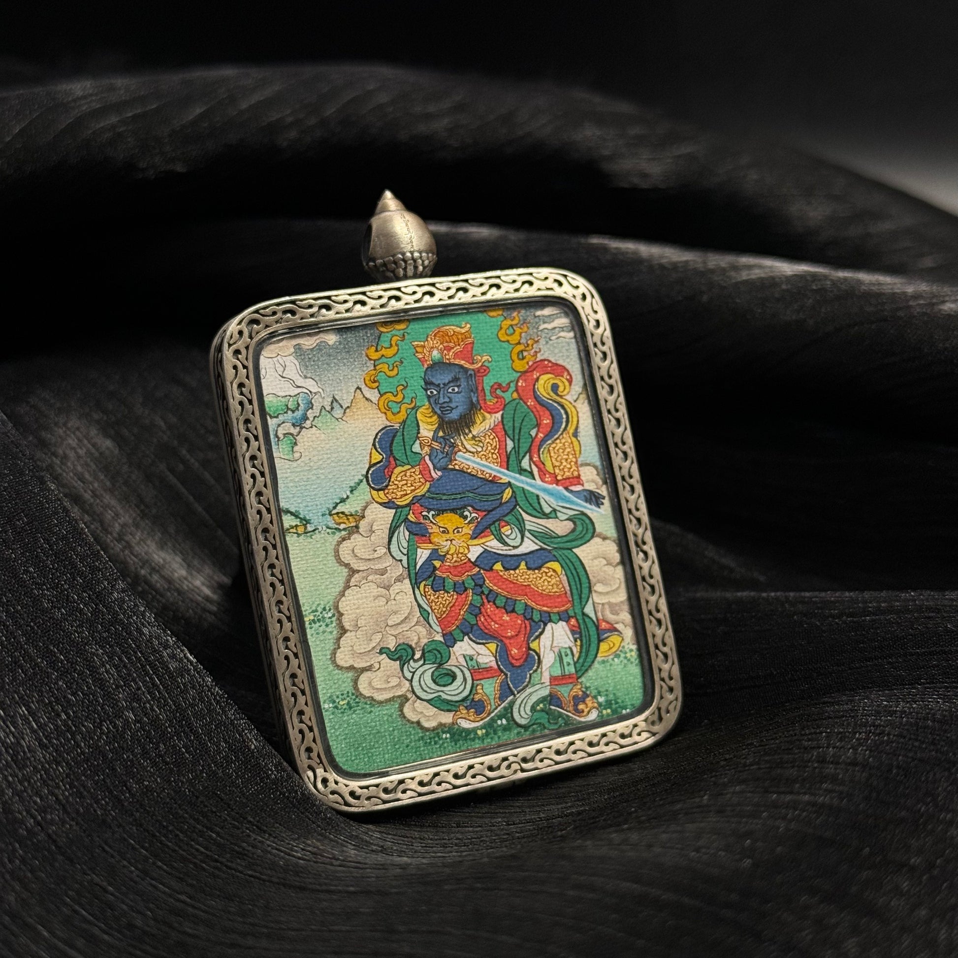 Detailed view of Virudhaka Southern Guardian King deity painting in mini thangka pendant with traditional Tibetan iconography