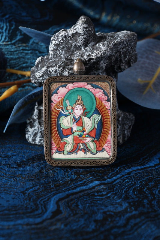 Close-up of the White Lhamo mini thangka pendant highlighting hand-painted mineral pigment craftsmanship and the sterling silver case, suitable for collectors and practitioners seeking a portable Tibetan thangka piece.