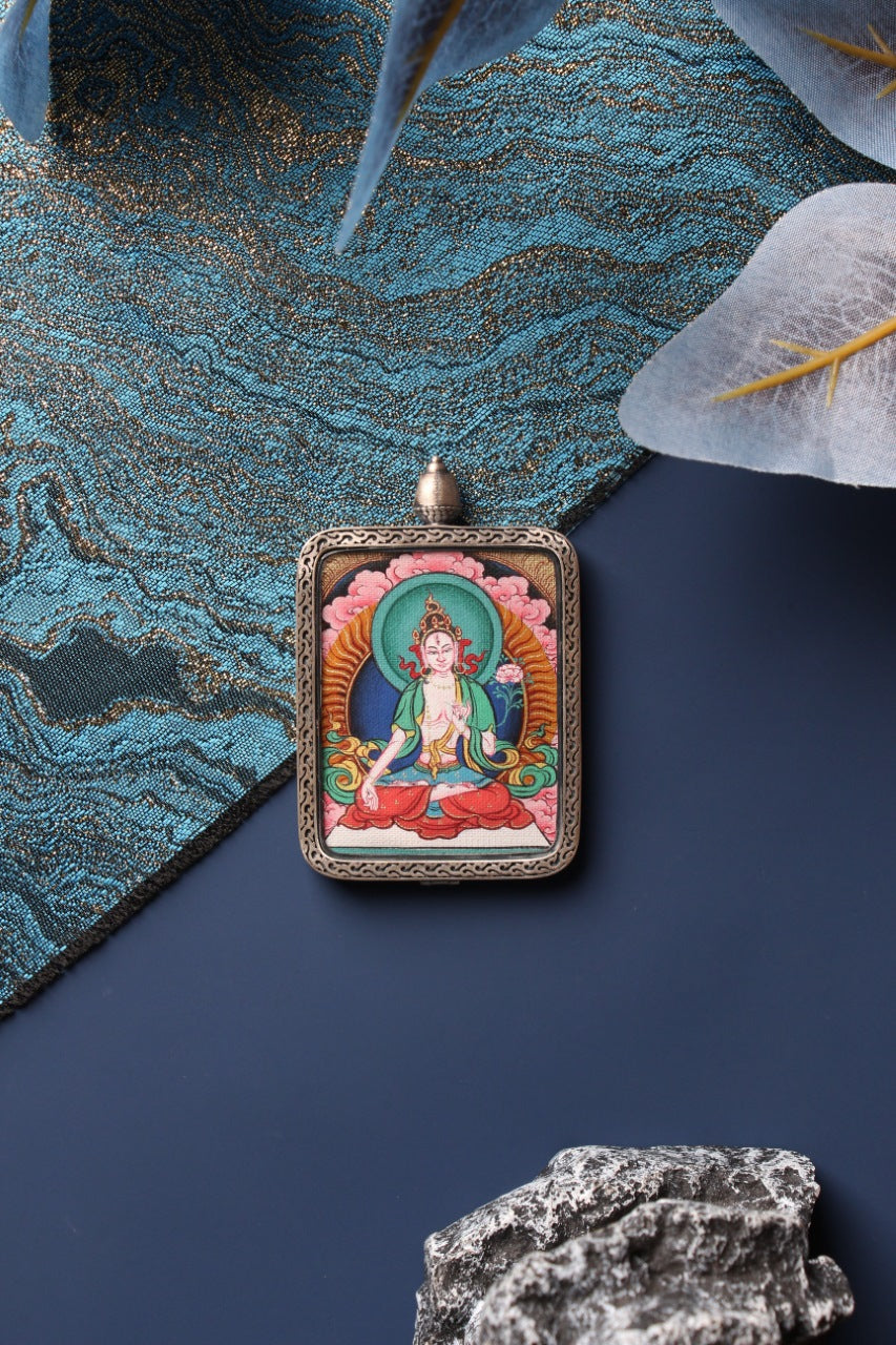 Front view of the White Tara mini thangka pendant in Zangka format, a compact Tibetan devotional artwork hand-painted in Tibet with mineral pigments and protected by a sterling silver case for travel and personal shrine use.