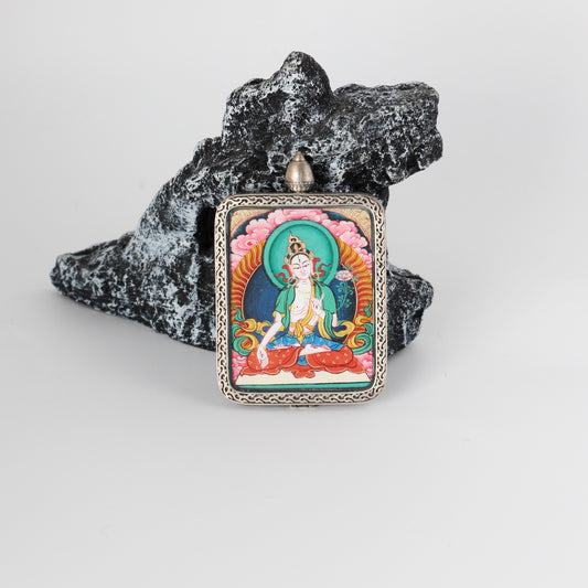 Front view of White Tara mini Thangka pendant, hand-painted with mineral pigments, set in a pure silver case with traditional Tibetan decorative patterns.